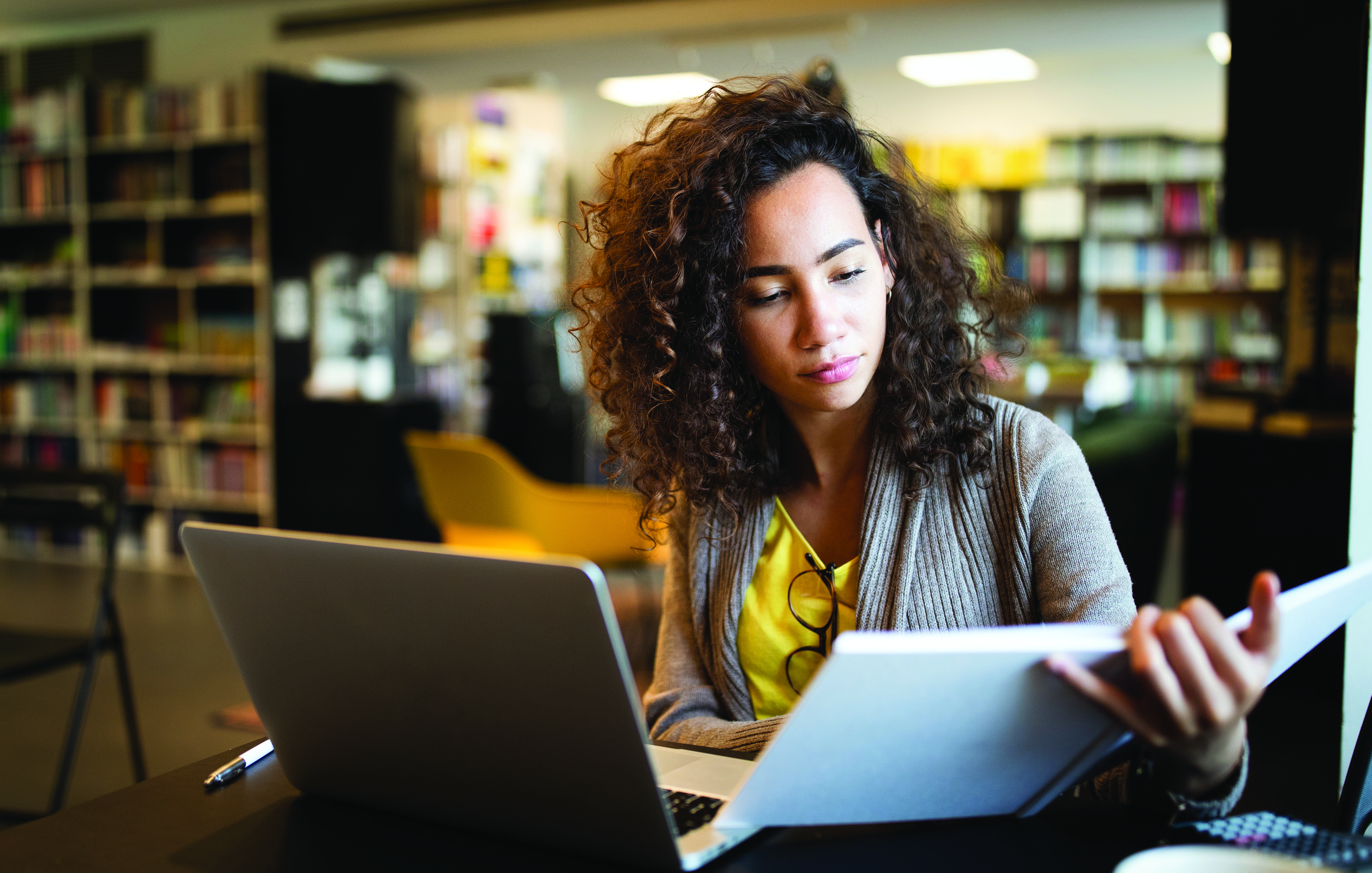woman sitting in a library reading