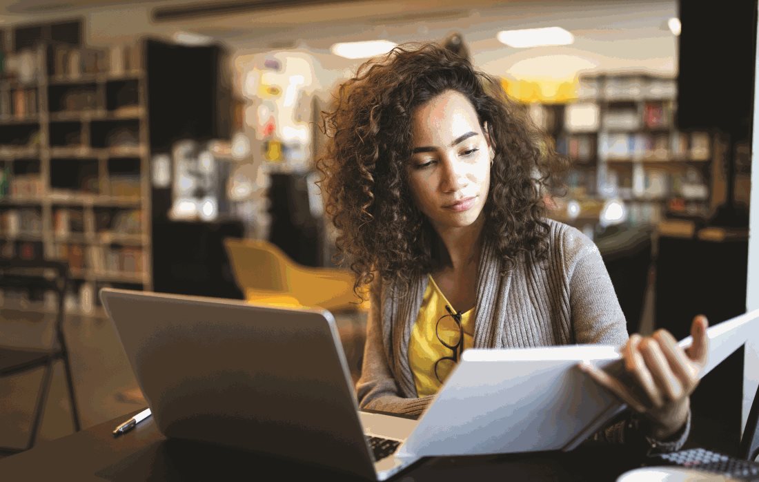 woman sitting in a library reading